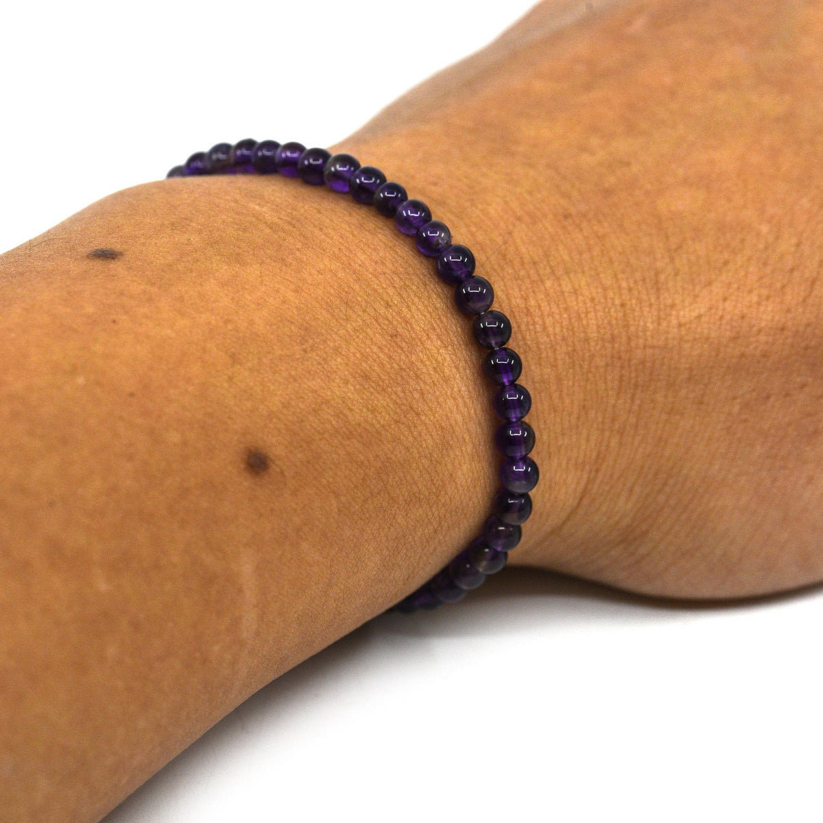 Amethyst 4mm bracelet resting on its crystal properties card — Eternal Spirit