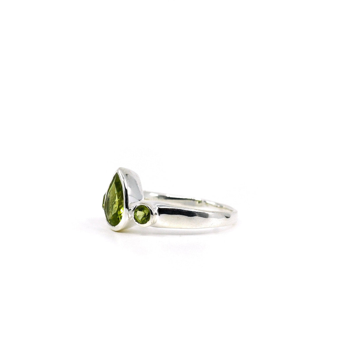 Peridot ring #R697 angled to reveal its polished setting and silver band — Eternal Spirit