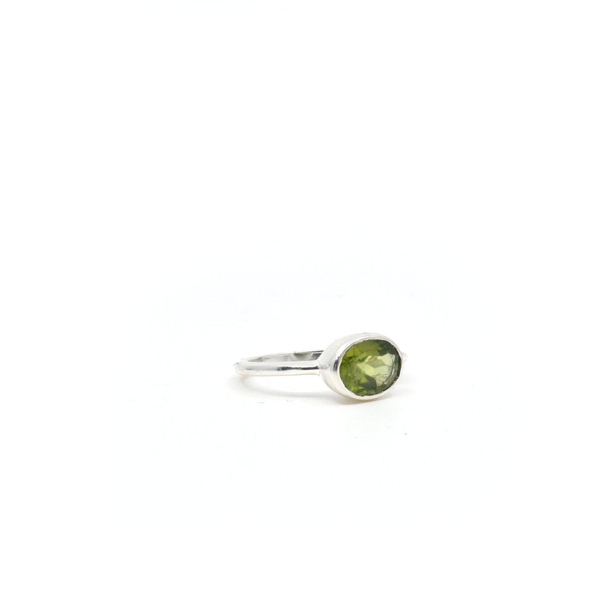 Peridot ring #R338 angled to reveal its polished setting and silver band — Eternal Spirit