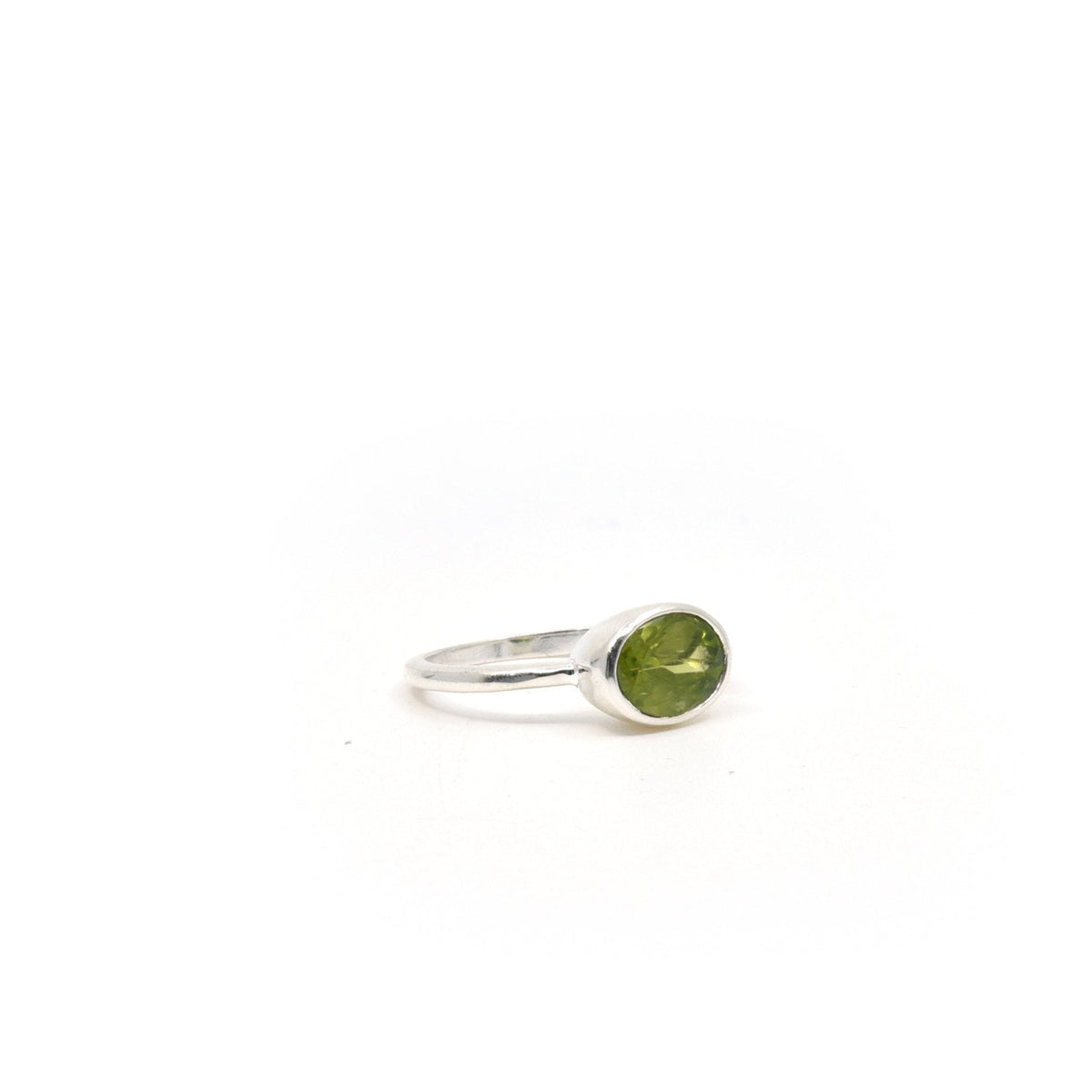 Peridot ring #R339 angled to reveal its polished setting and silver band — Eternal Spirit