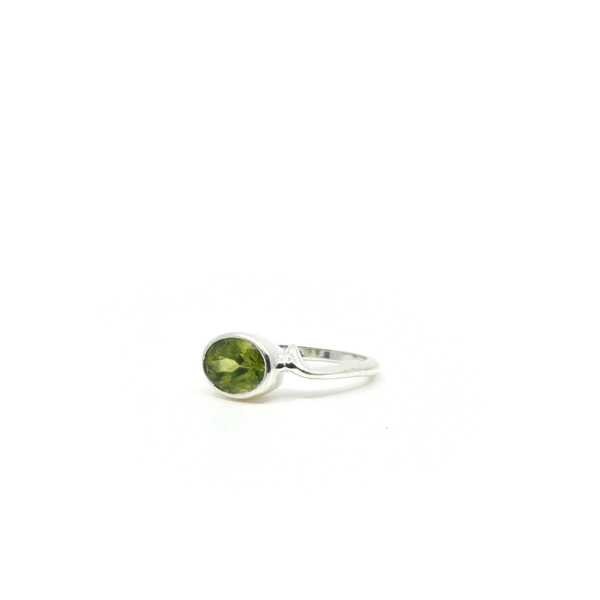 elegant side profile of Peridot ring #R339, the gemstone catching light — Eternal Spirit