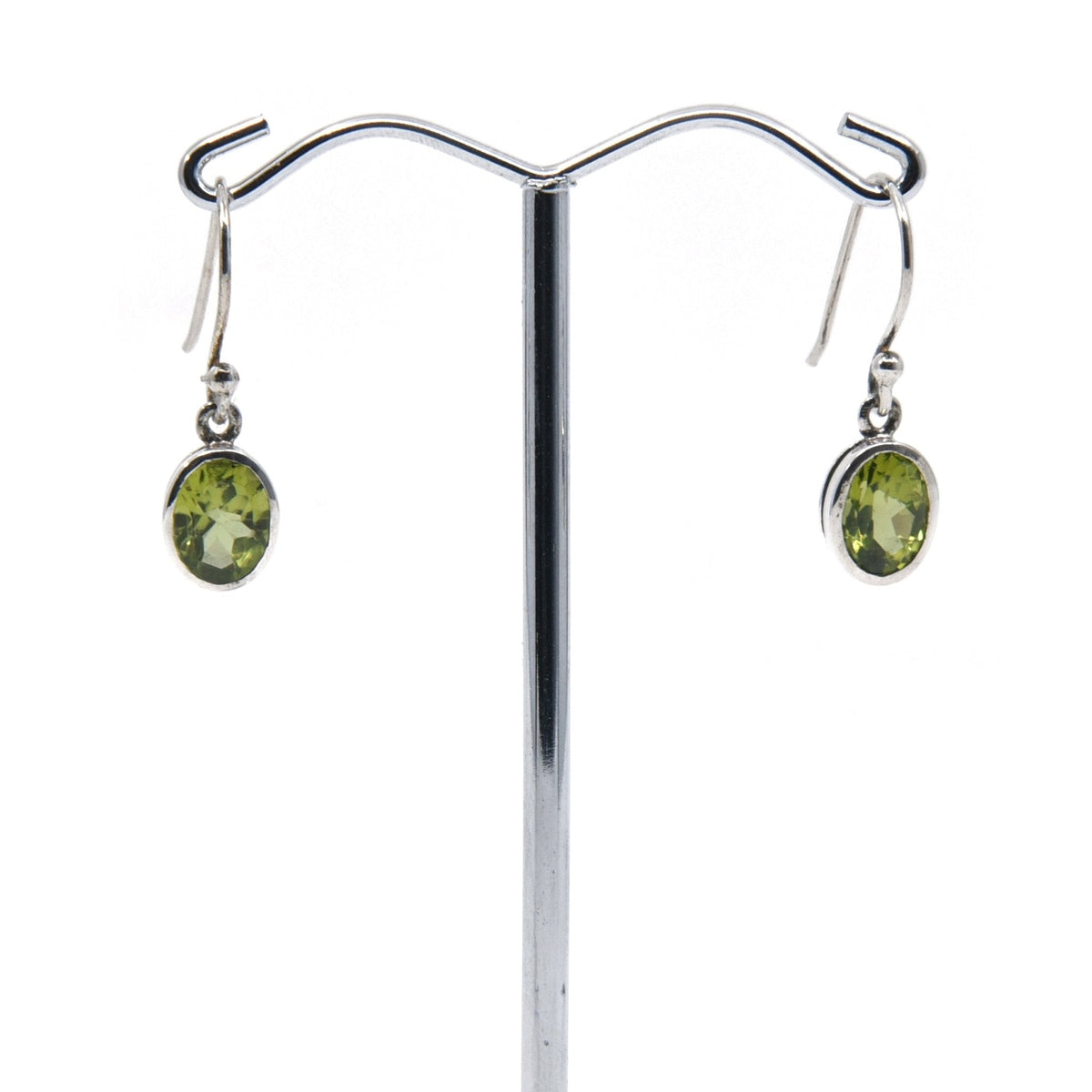 peridot faceted oval earrings with silver setting on white background — Eternal Spirit