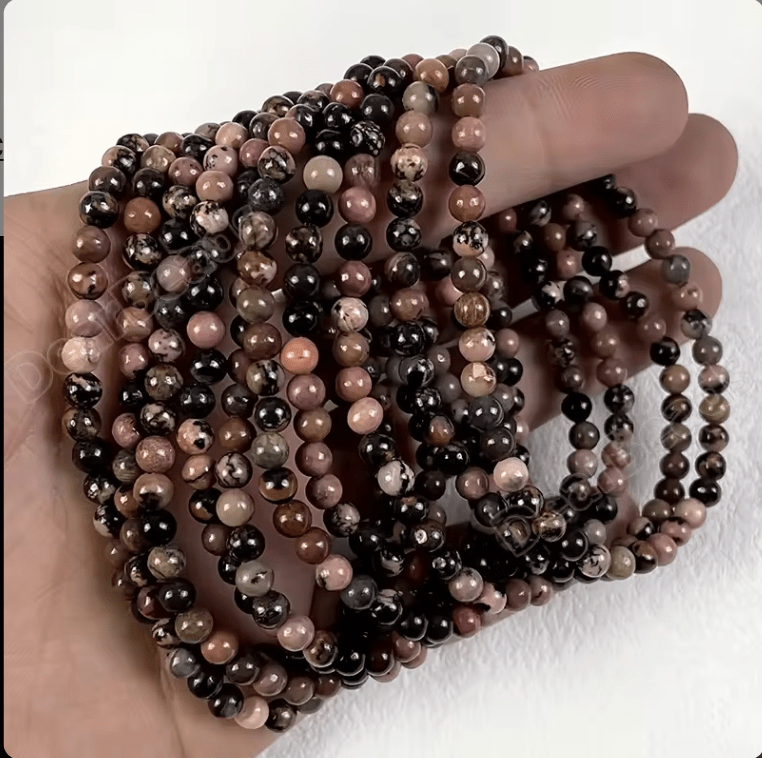 Rhodonite 4mm bracelet resting on its crystal properties card — Eternal Spirit