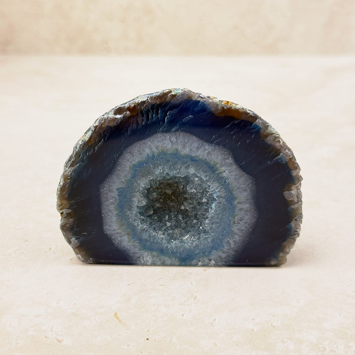 Agate crystal geode 8cm, navy-grey and pale blue-grey bands around a sparkling centre, front view — Eternal Spirit