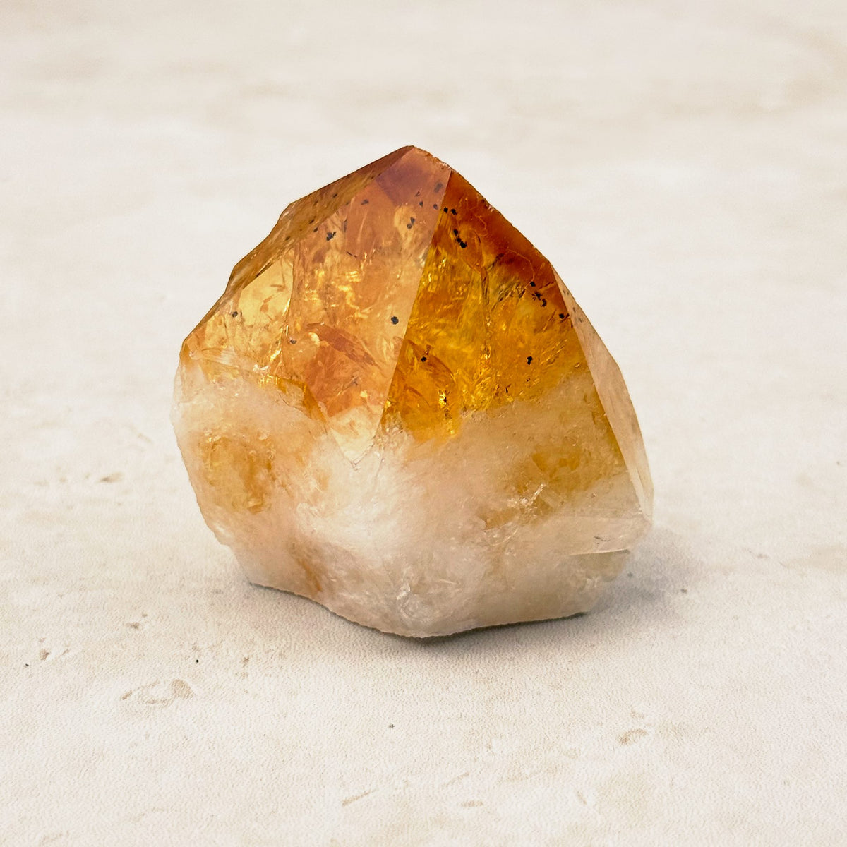 Heated citrine base cut crystal 5cm, bright amber tip on a white quartz base, front view — Eternal Spirit