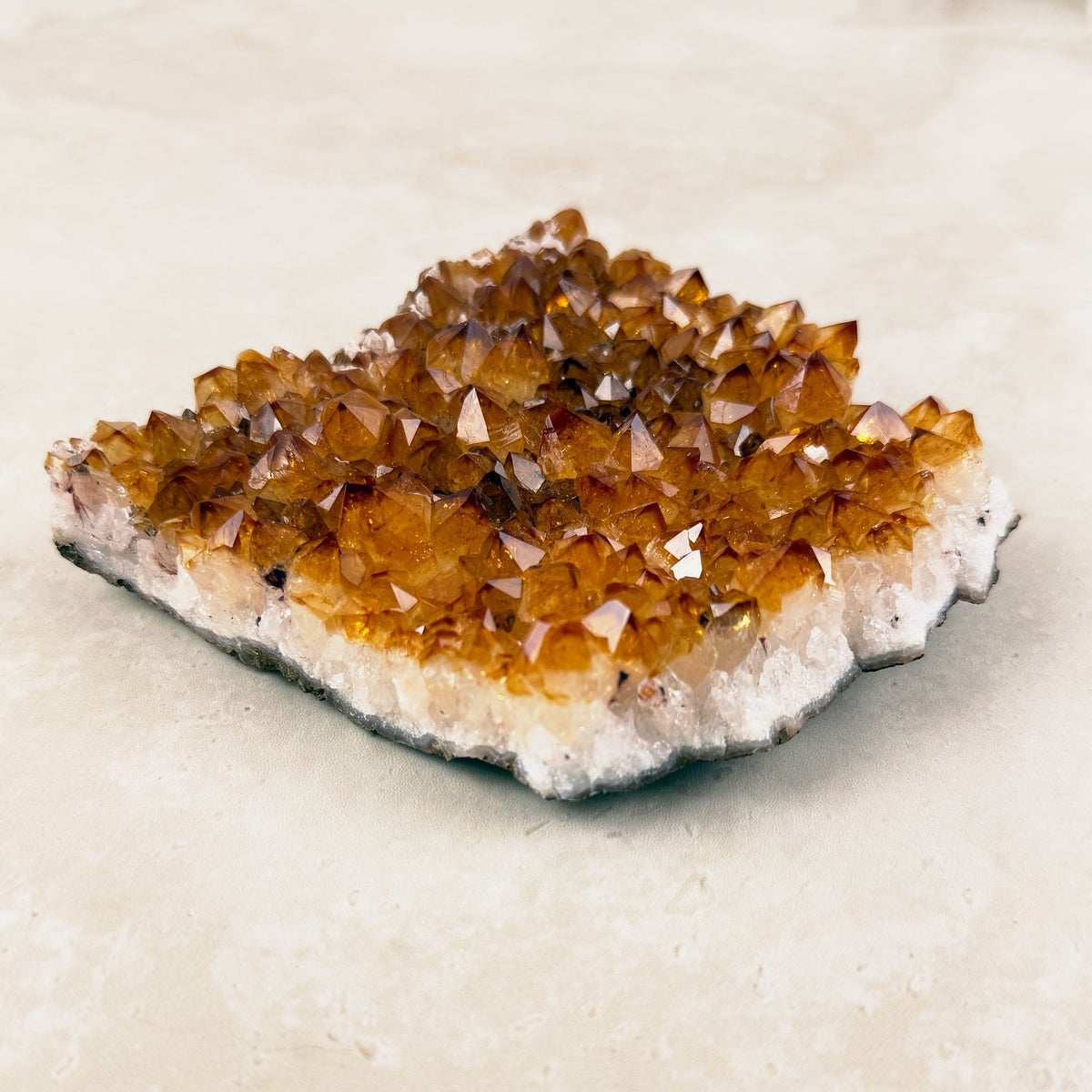 Heated citrine crystal cluster 14cm, low flat plate of amber points on a white base, side view — Eternal Spirit