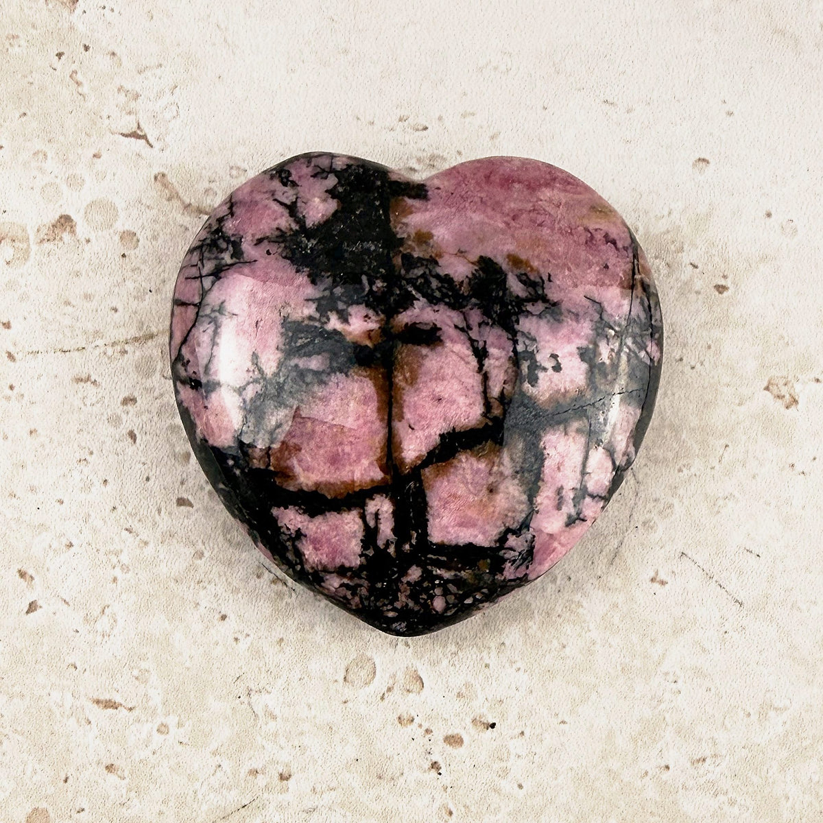 Marbled rhodonite crystal heart 5cm, pink and black marbling, angled view — Eternal Spirit