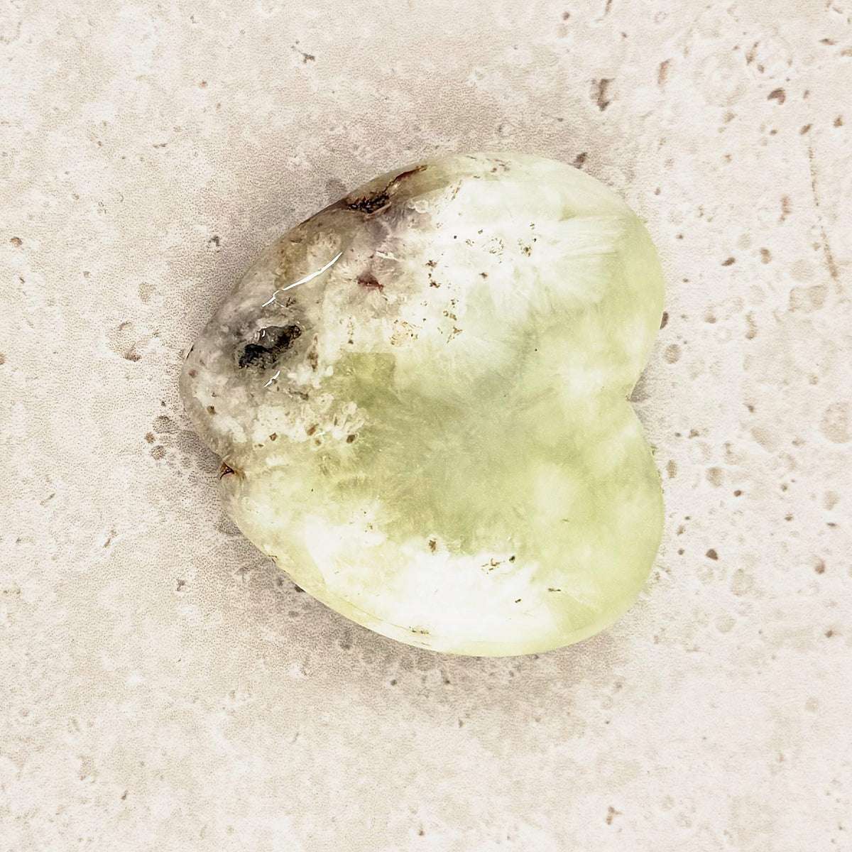 Prehnite crystal heart 5.5cm, lime green with a darker inclusion near the top, angled view — Eternal Spirit