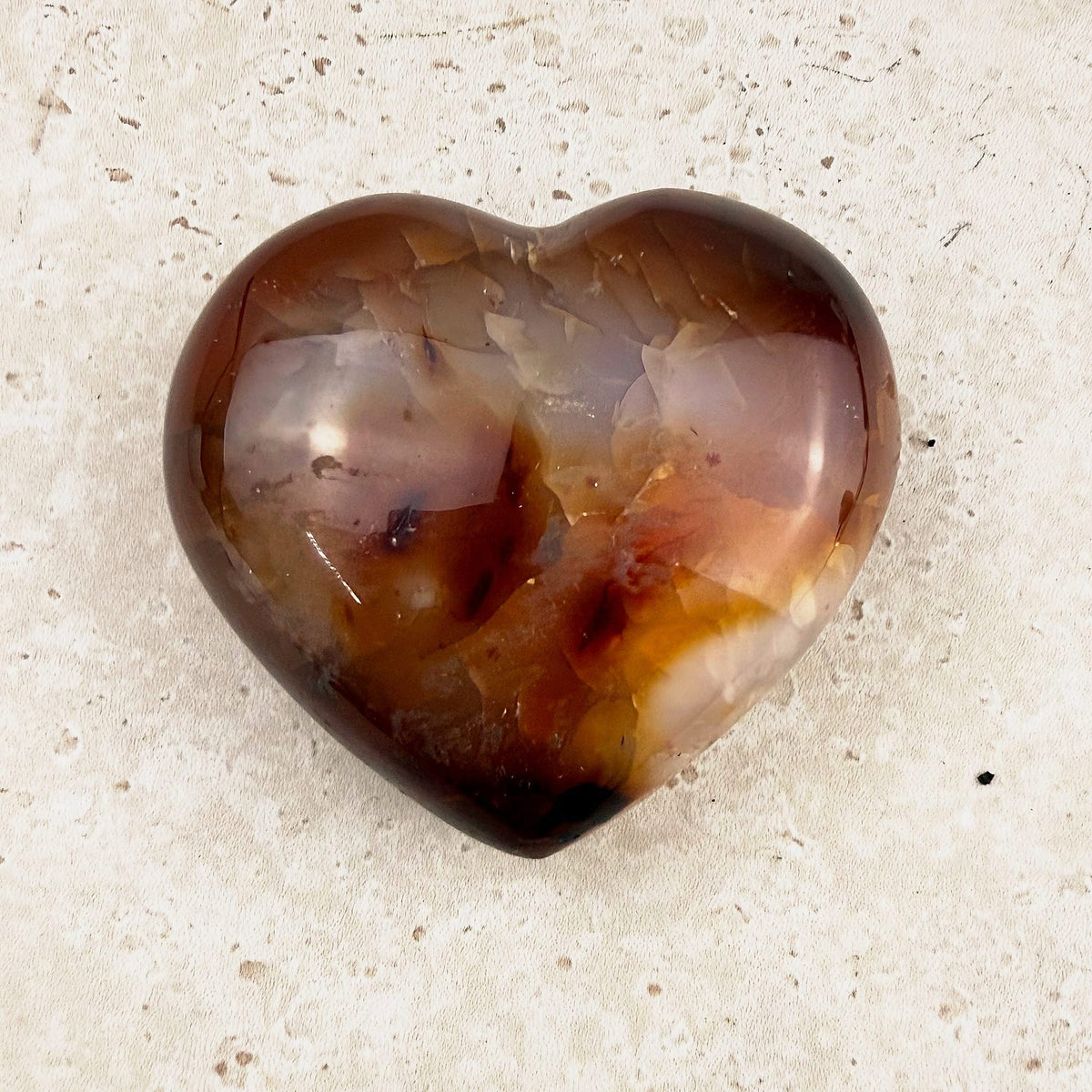 Speckled carnelian crystal heart 6cm, amber and red-brown tones, angled view — Eternal Spirit