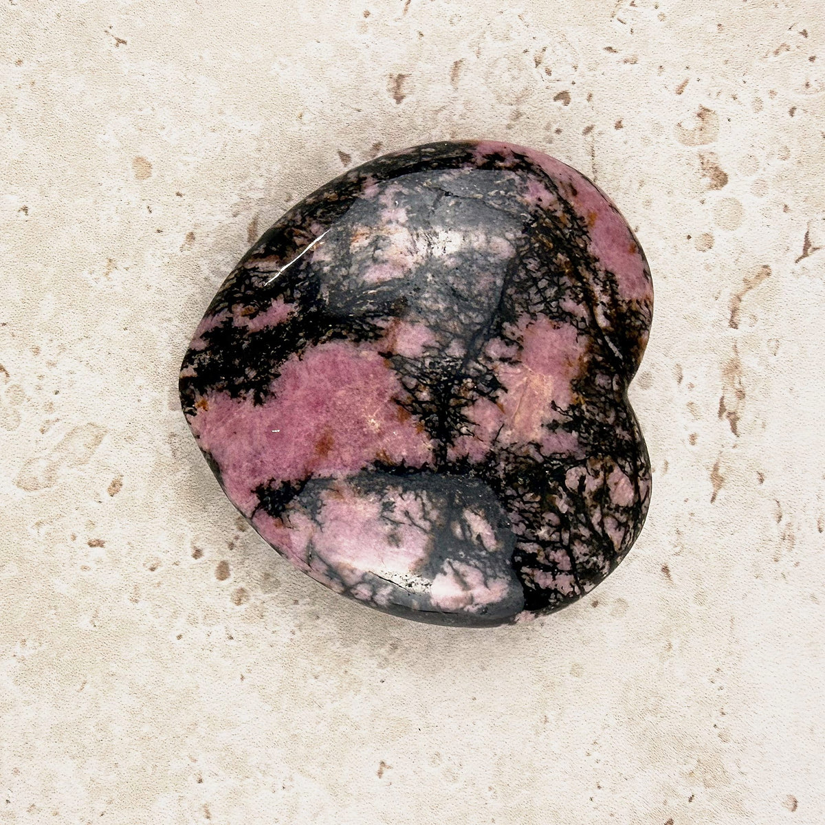 Veined rhodonite crystal heart 5cm, pink and black pattern on a polished face, angled view — Eternal Spirit