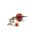 Close-up of Carnelian sphere pendulum, fiery orange stone detail — Eternal Spirit