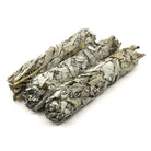 white sage smudge sticks (various sizes), aromatic smoke curling from a lit bundle — Eternal Spirit