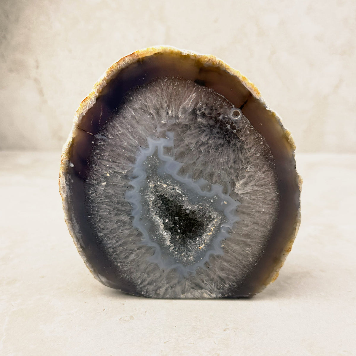 Agate crystal geode 11.5cm, grey and blue bands around a sparkling hollow centre, front view — Eternal Spirit