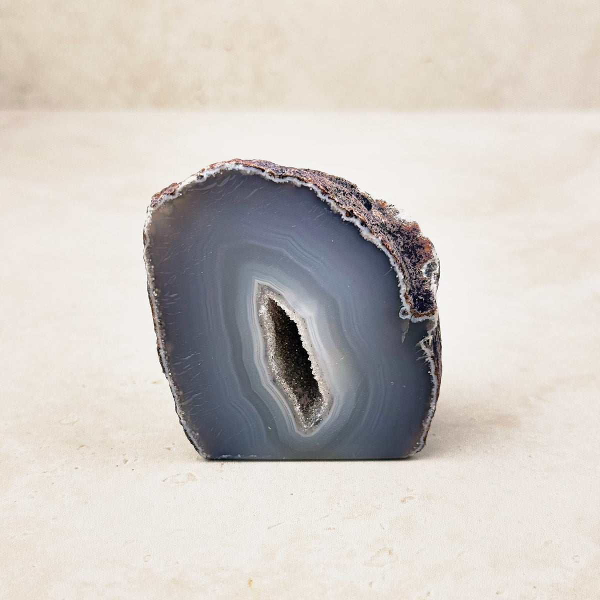 Agate crystal geode 6cm, grey and white bands around a narrow crystal hollow, front view — Eternal Spirit