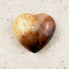 Banded carnelian crystal heart 6cm, cream top shading to chestnut, front view — Eternal Spirit