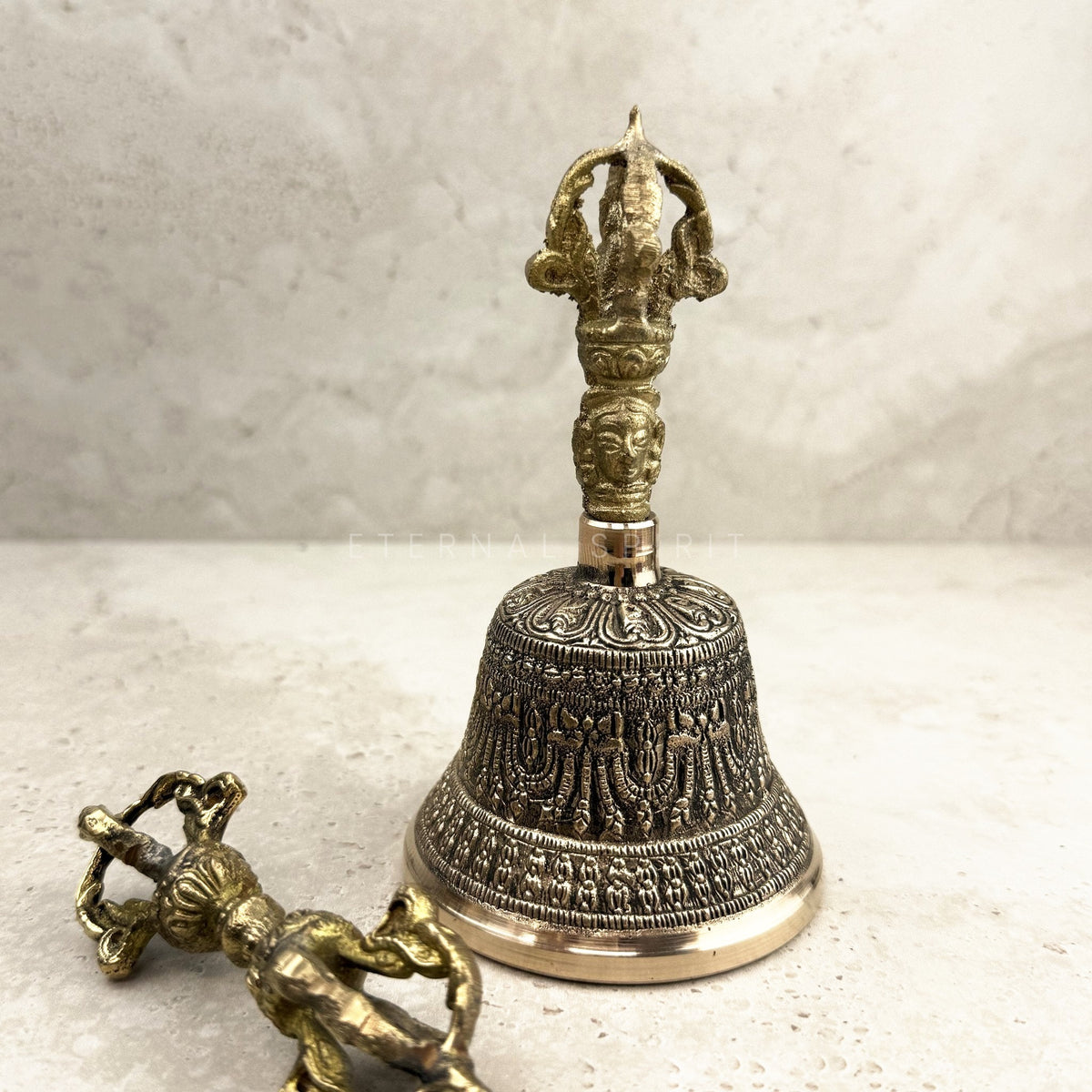 Brass Tibetan bell 14.5cm with dorje, ornate front view of the face-carved handle — Eternal Spirit