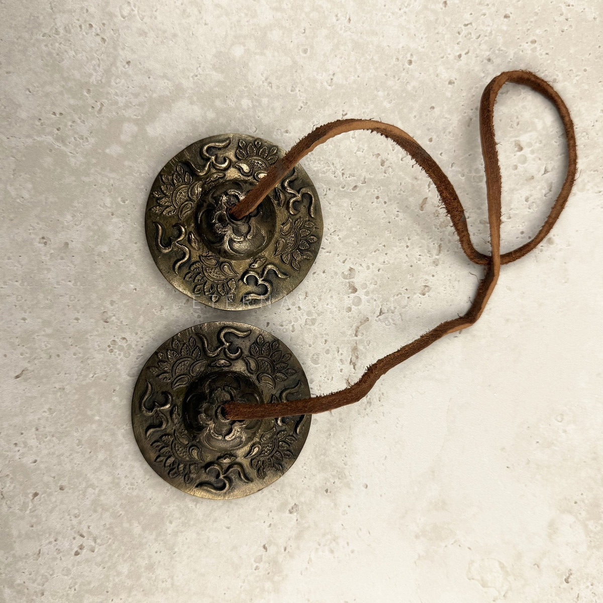 Bronze and brass Lotus tingsha cymbals 6cm, paired on a looped leather strap, viewed from above — Eternal Spirit