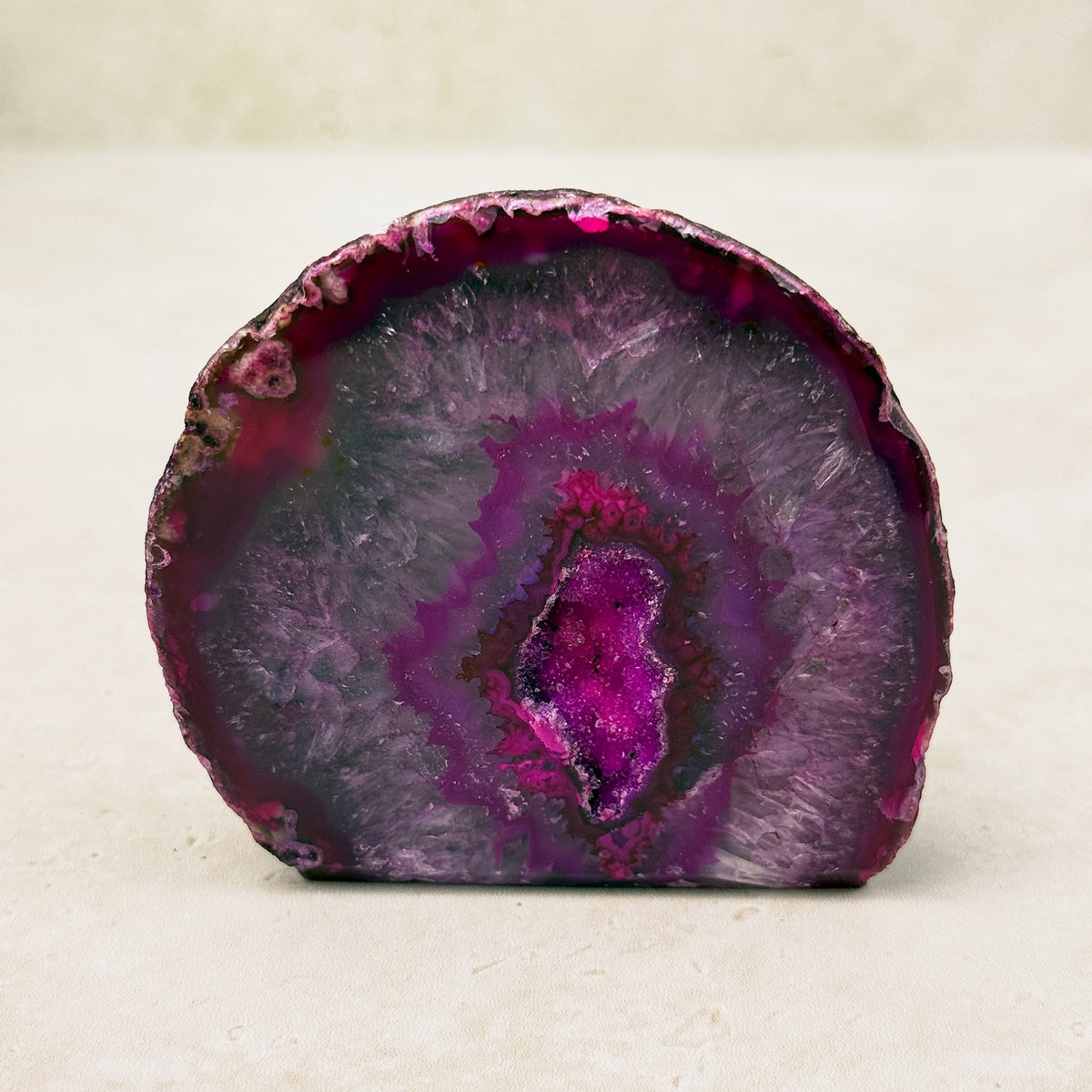 Dyed pink agate crystal geode 7.5cm, magenta bands around a sparkling pink hollow, front view — Eternal Spirit