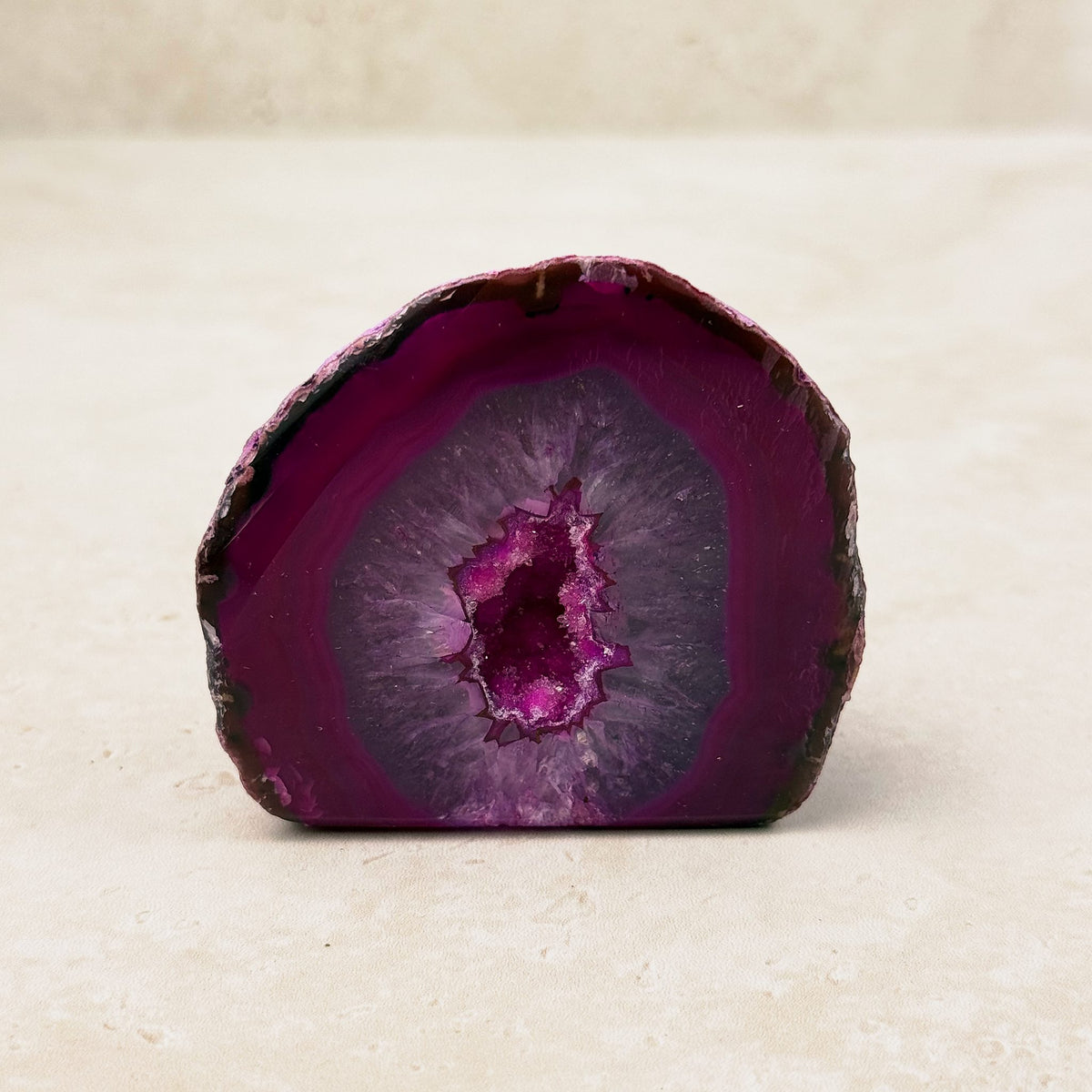 Dyed pink agate crystal geode 6.5cm, pink bands around a bright pink crystal hollow, front view — Eternal Spirit