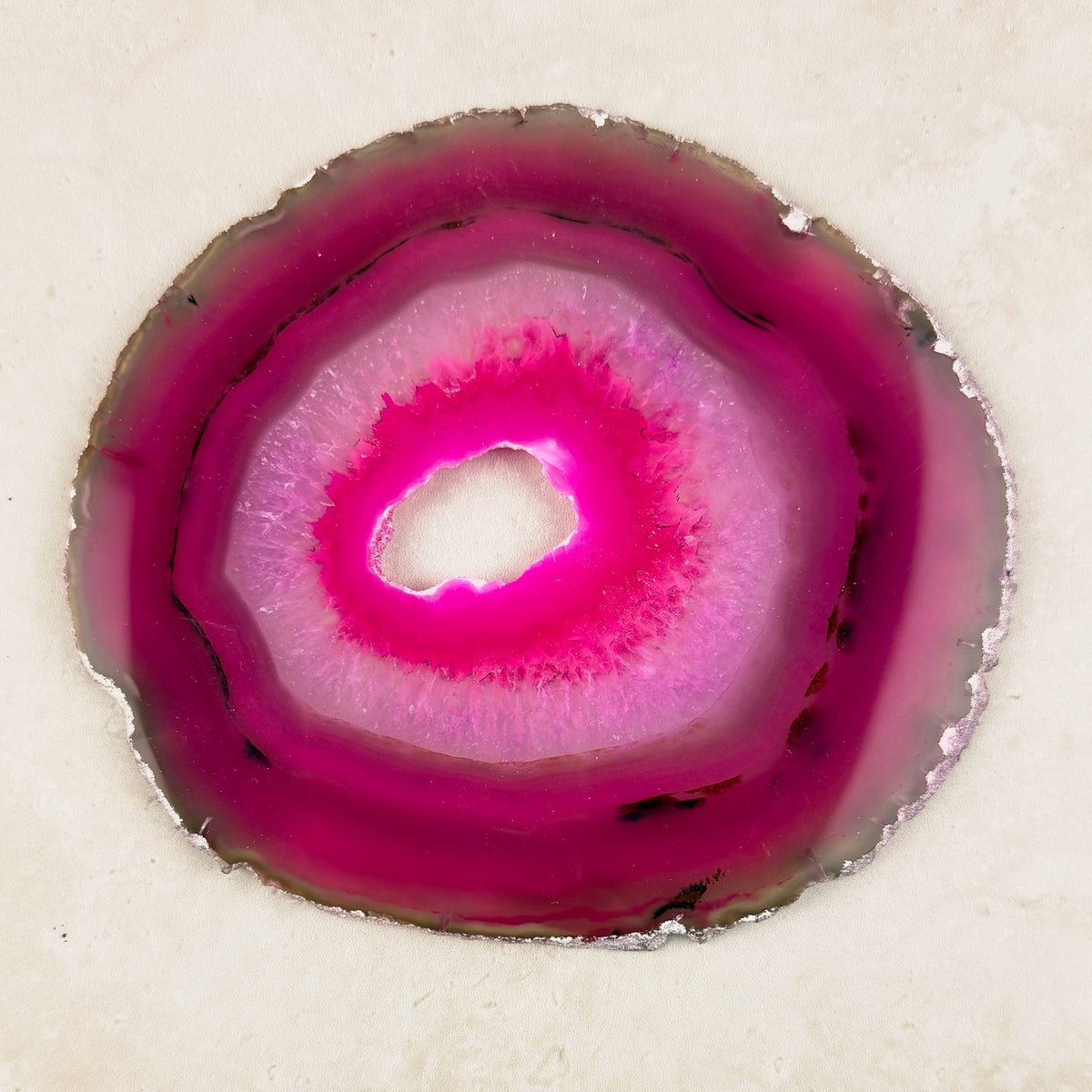 Dyed pink agate crystal slice 14cm, hot pink rings around an open centre, viewed from above — Eternal Spirit