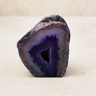 Dyed purple agate crystal geode 6.5cm, purple bands around a dark crystal hollow, front view — Eternal Spirit