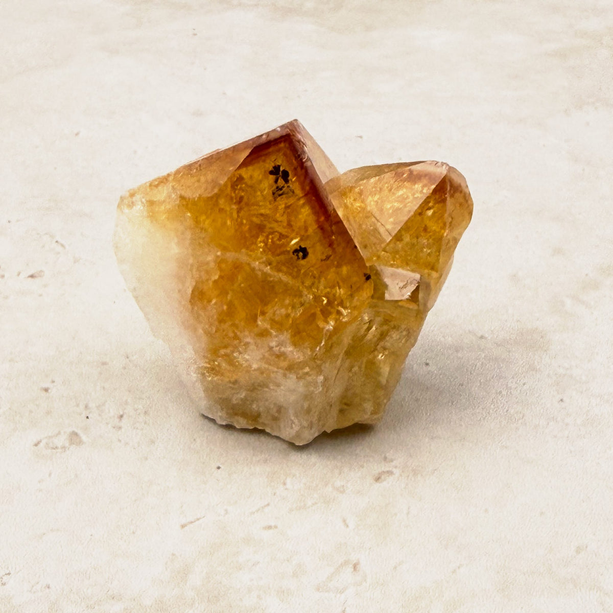 Heated citrine base cut crystal 5cm, amber tips on a white quartz base, front view — Eternal Spirit