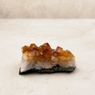 Heated citrine crystal cluster 7.5cm, small amber points on a white and grey base, low side view — Eternal Spirit