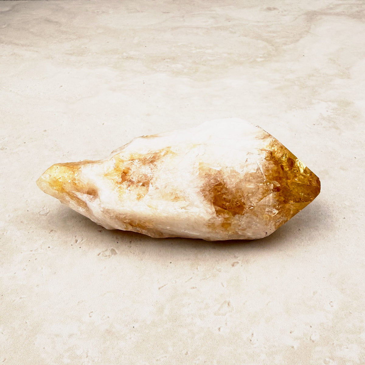 Heated citrine crystal point 10cm, white quartz body with an amber tip, lying on its side — Eternal Spirit