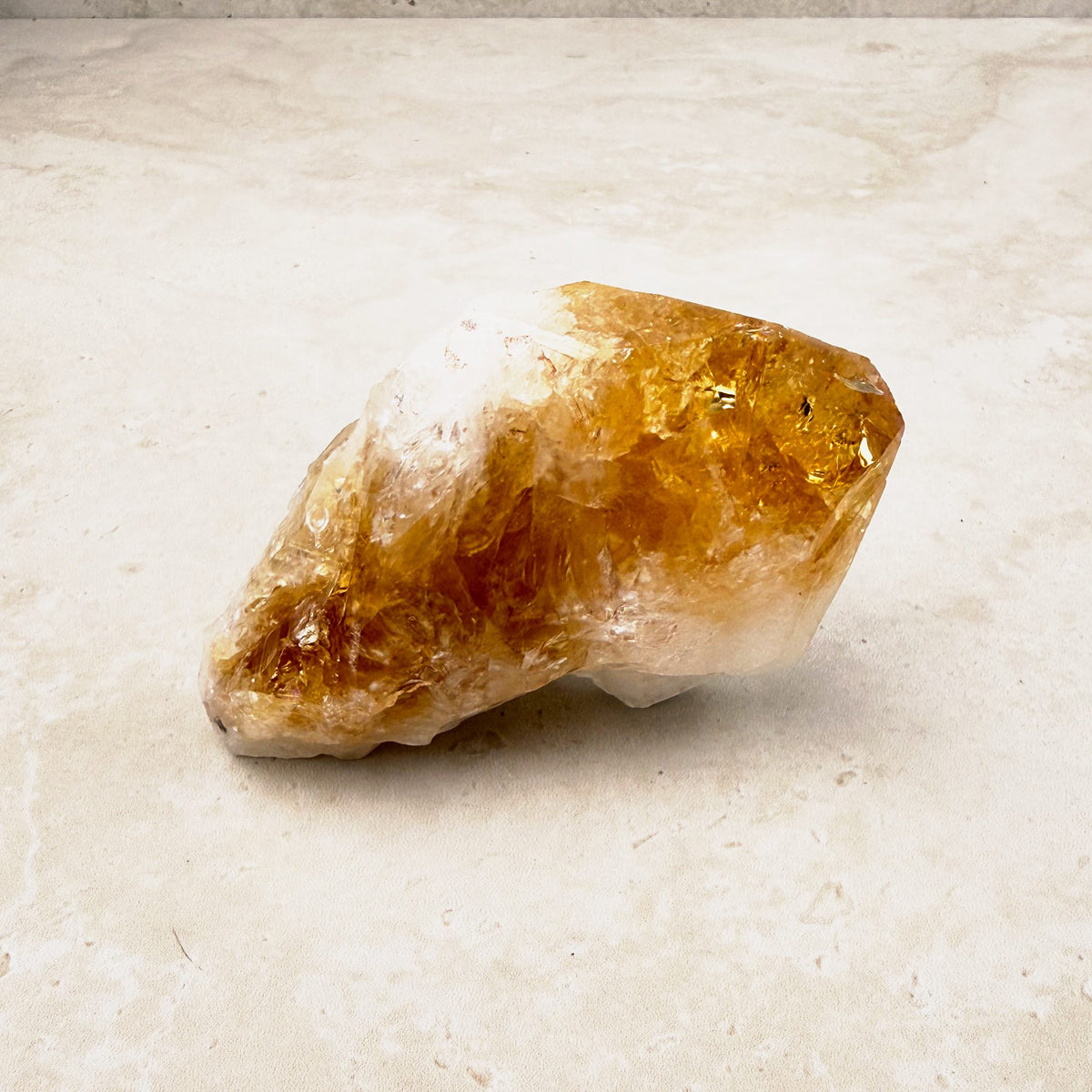 Heated citrine crystal point 9.5cm, amber faces over a white base, lying on its side — Eternal Spirit