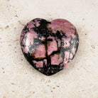 Marbled rhodonite crystal heart 5cm, pink and black marbling, angled view — Eternal Spirit