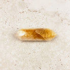 Slender heated citrine crystal wand 8.5cm, amber band through the middle, white tips, side view — Eternal Spirit