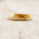 Slender heated citrine crystal wand 8.5cm, glowing amber centre fading to white points, low side view — Eternal Spirit