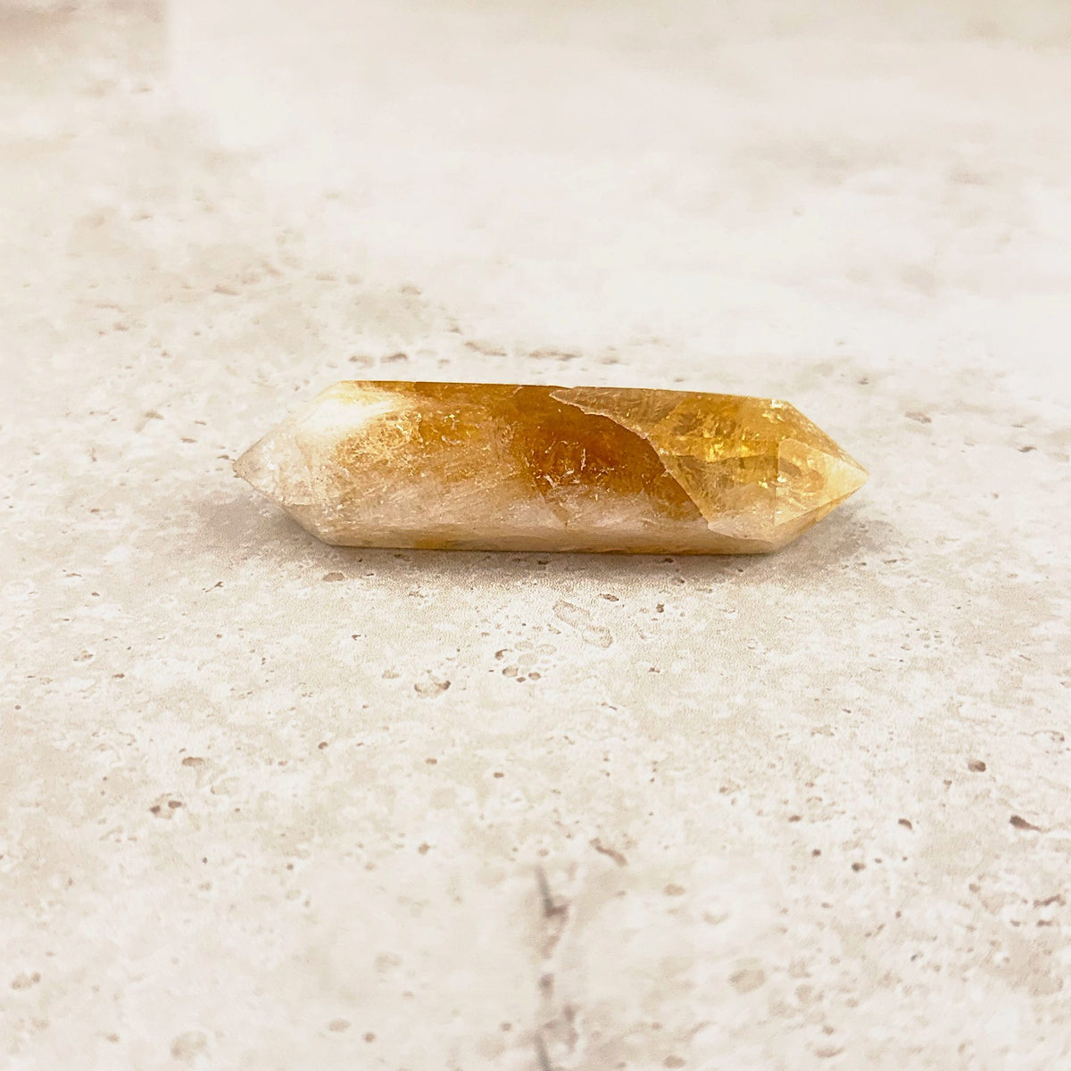 Slender heated citrine crystal wand 8.5cm, glowing amber centre fading to white points, low side view — Eternal Spirit