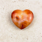 Wide carnelian crystal heart 6.5cm, glowing orange with fine white lines, viewed from above — Eternal Spirit